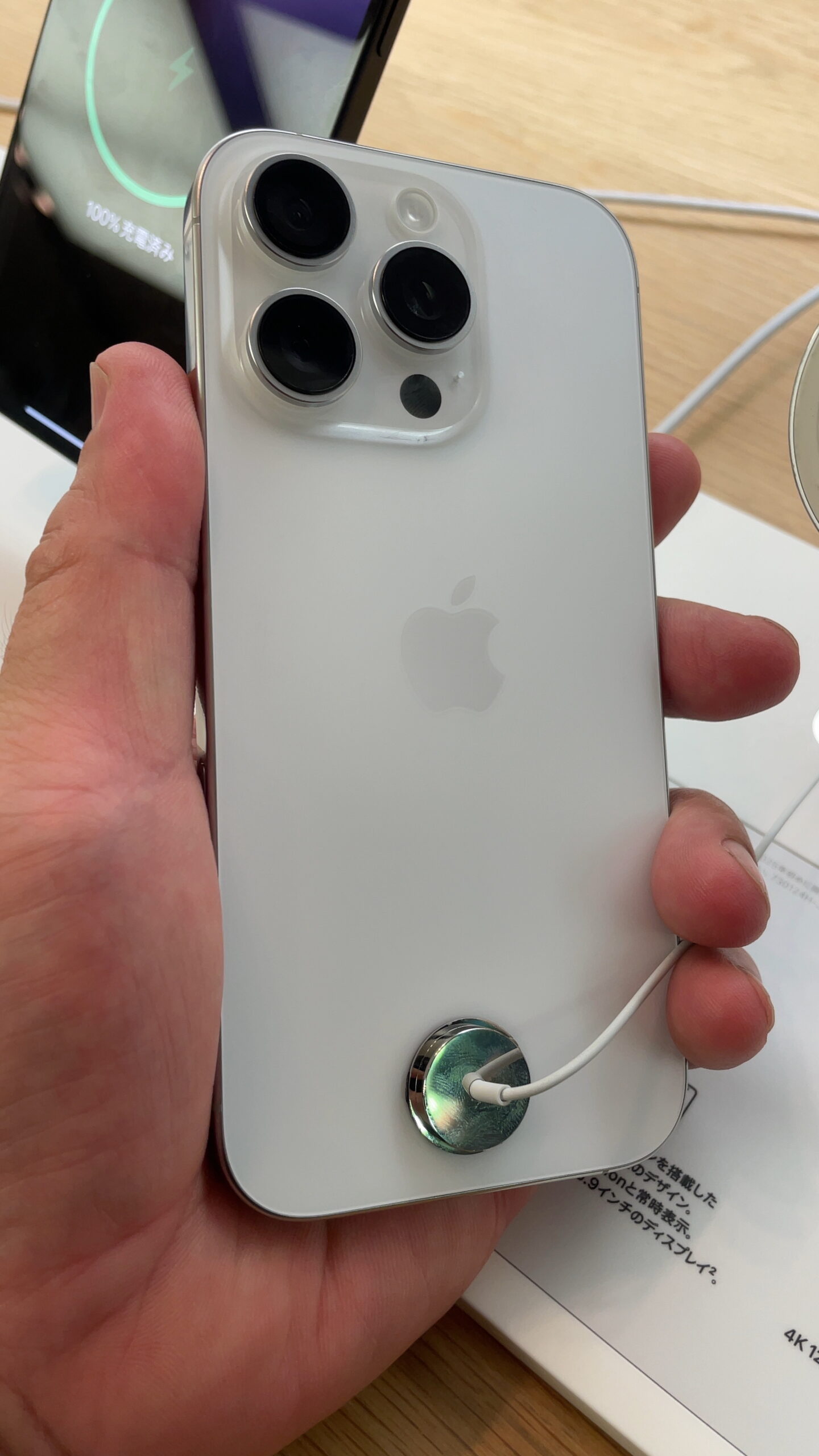 Hand holding an iPhone 16 Pro showing the camera and Face ID sensor housing